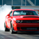 A Dodge Challenger SRT Demon smoking its tires, as a Demon should, and as a Demon cannot do in a showroom.